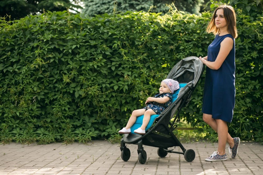 a women with baby storller in garden